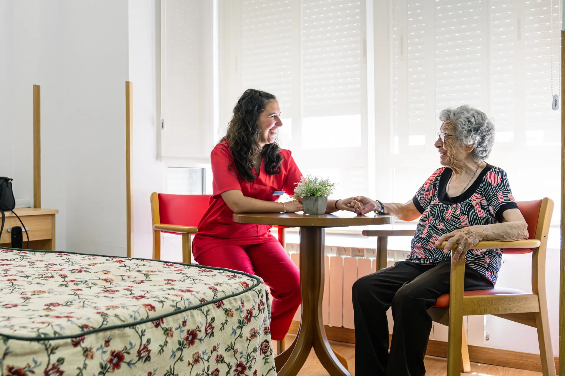 A caregiver and a resident in conversation by a window